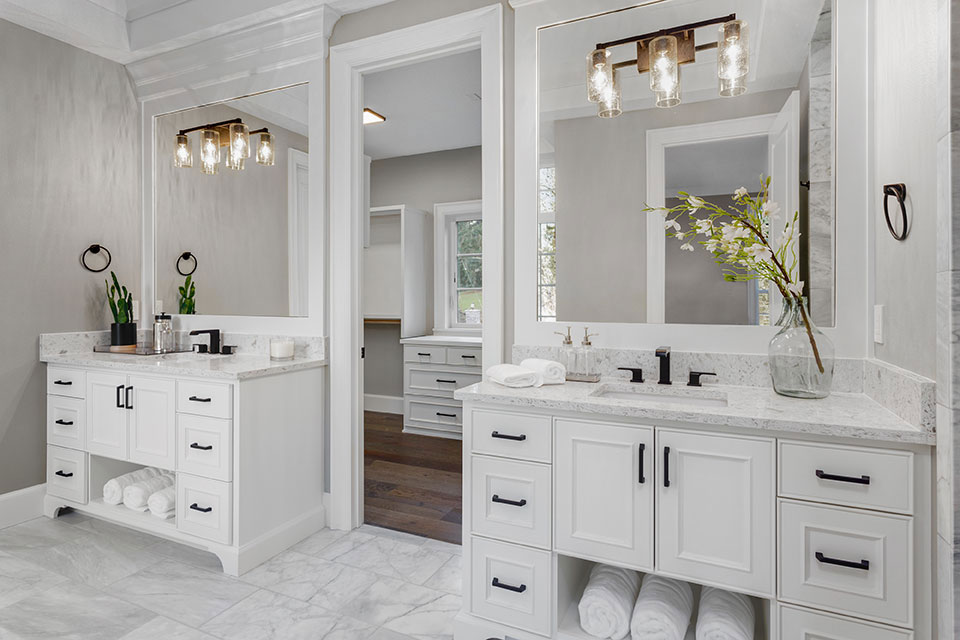 renovated bathroom with white lower cabinets